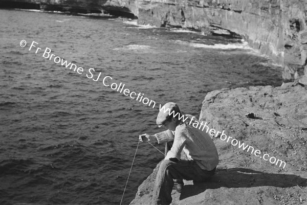 BOY FISHING FROM CLIFF